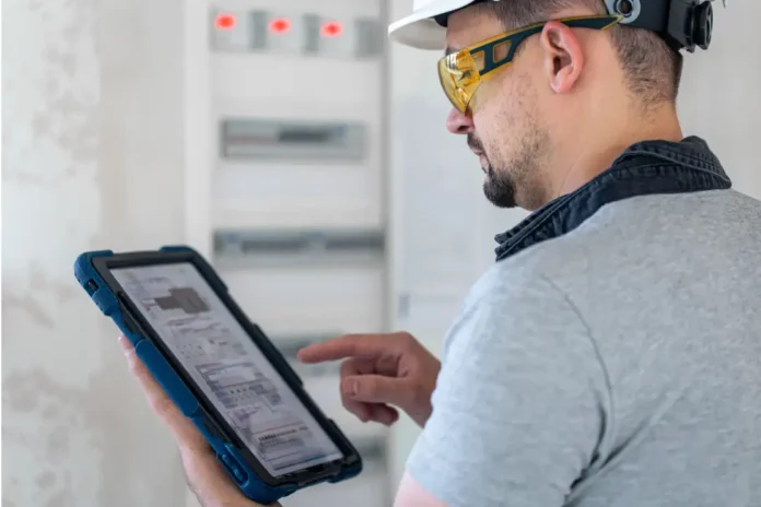 Técnico gestionando paneles electrónicos desde su tablet